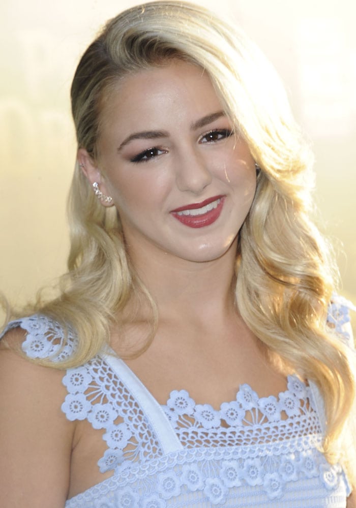 Chloe Lukasiak wears her blonde hair side-parted and curled at the premiere of "Pete's Dragon"