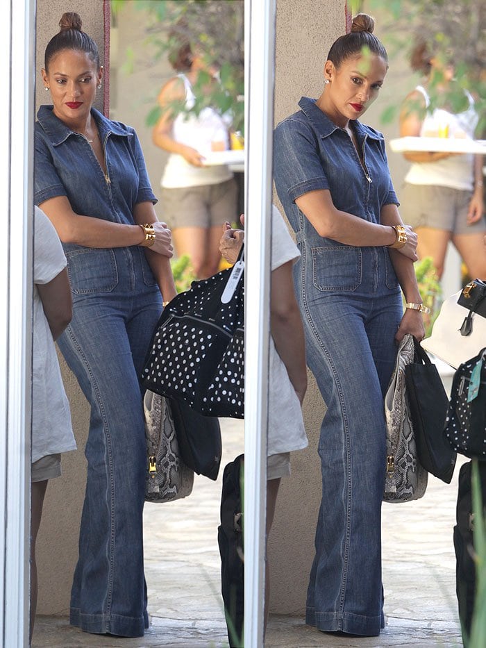 Jennifer Lopez accessorizes her denim Majorelle jumpsuit with a python-print bag from Tom Ford