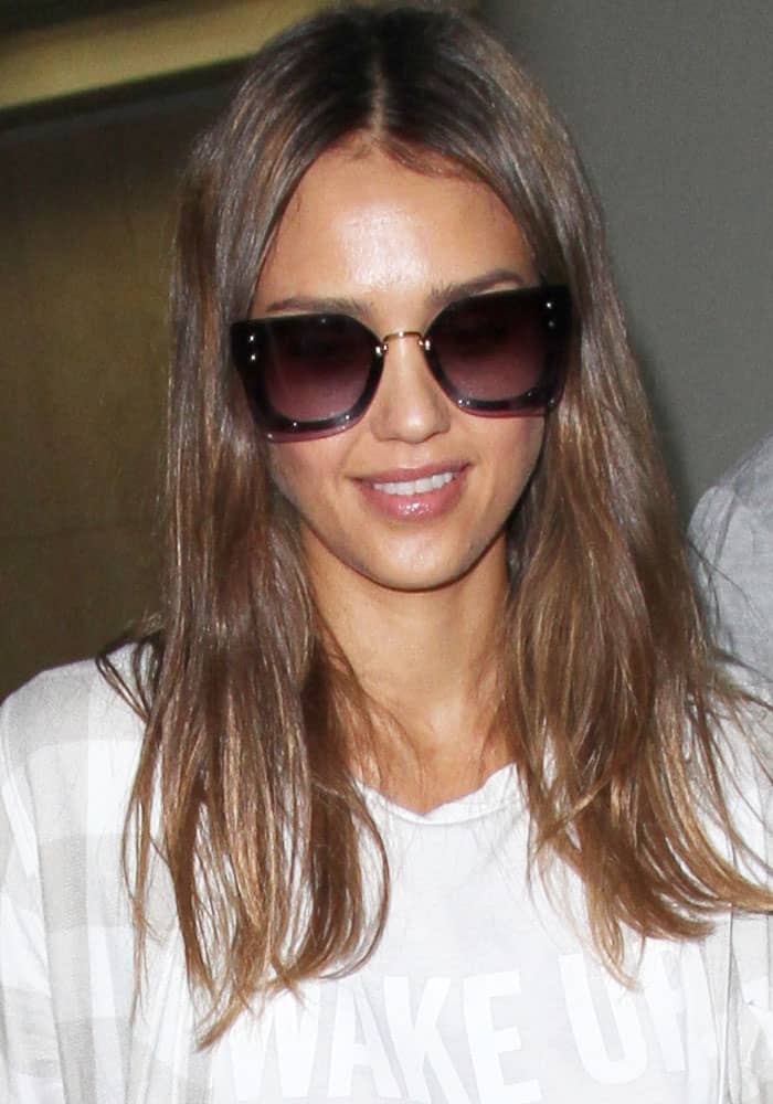 Jessica Alba let her chestnut hair cascade naturally as she arrived at the Los Angeles International Airport