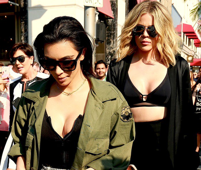 Kim Kardashian wears an olive green shirt and oversized black sunglasses while out on Rodeo Drive