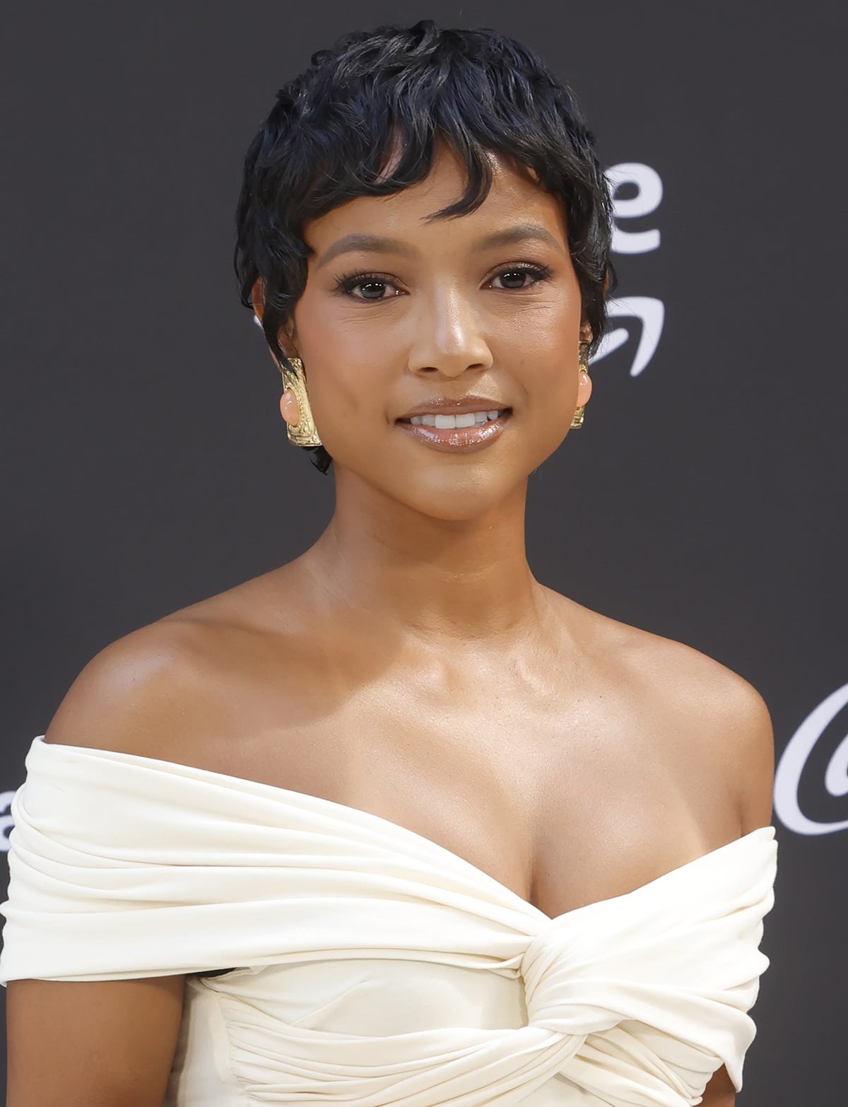 Karrueche Tran sported a short pixie cut, highlighting her beautiful features and high cheekbones, and looked radiant in a white off-the-shoulder Khaite blouse