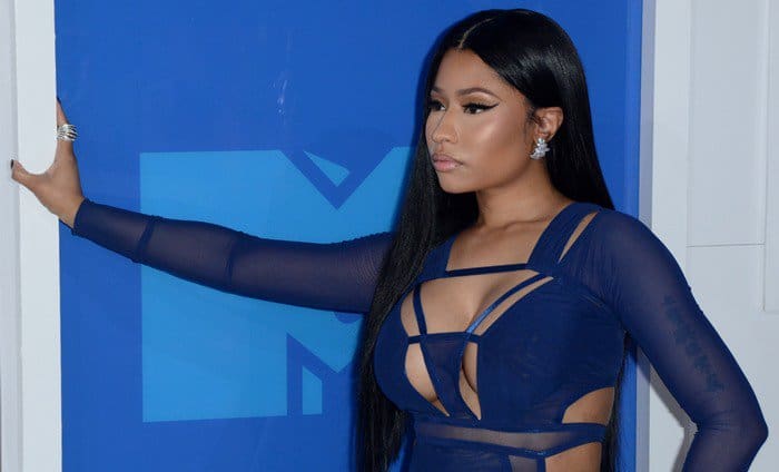 Nicki Minaj complements her sleek straight hair with dazzling diamond earrings and a statement ring