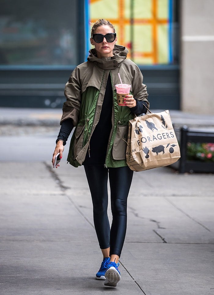 Olivia Palermo showcases her effortless street style in New York City, pairing a green Moncler jacket with sleek leggings and vibrant blue Nike Roshe One Flyknit sneakers