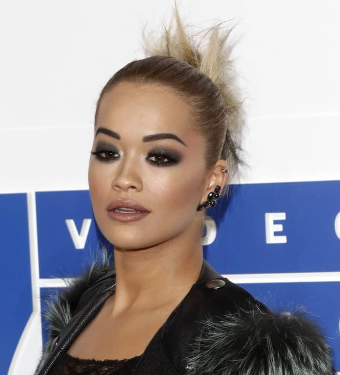 Rita Ora complements her bold look at the 2016 MTV Video Music Awards with smoky makeup, an edgy updo, and striking black ear cuffs