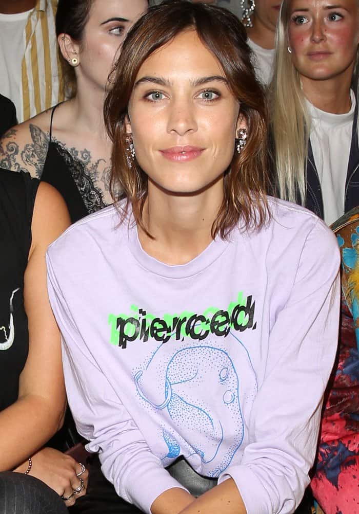 Alexa Chung's outfit choice was a nod to Williams, with her "pierced" graphic sweater stylishly tucked into a sleek black leather pencil skirt