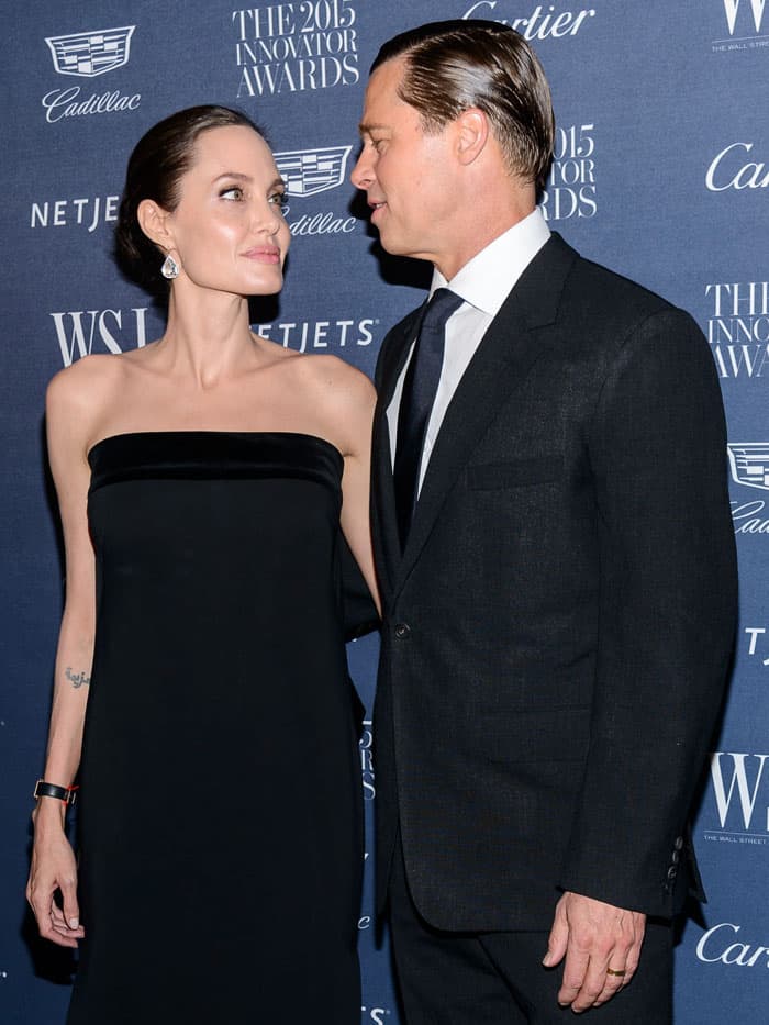 Capturing their love and admiration, Angelina Jolie and Brad Pitt, in a black Tom Ford velvet-bow gown and ankle-wrap pumps, maintain their elegance at the 2015 Innovator Awards in New York City