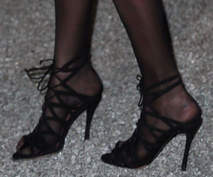 Cara Delevingne's lace-up sandals feature intricate crisscross straps, open toes, and sleek stiletto heels