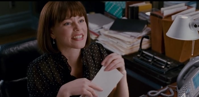 Elizabeth Banks as Betty Brant, the secretary to J. Jonah Jameson in Spider-Man, showcasing her charm in a polka-dot blouse while working at the iconic Daily Bugle office