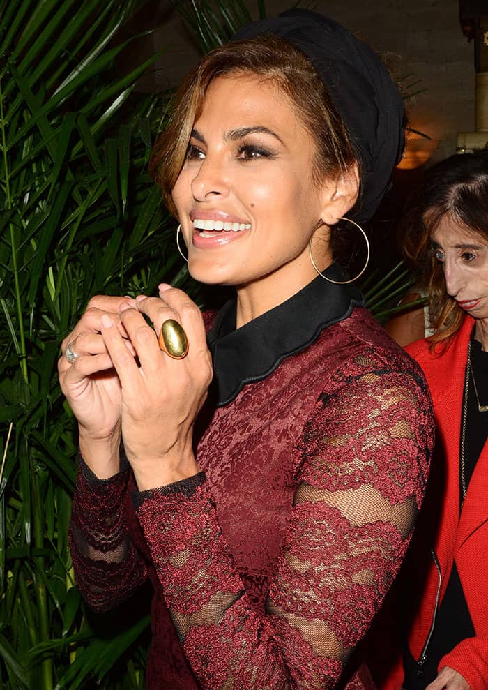 Eva Mendes' rich brunette hair was elegantly styled into a side-swept updo, crowned with a broad headband