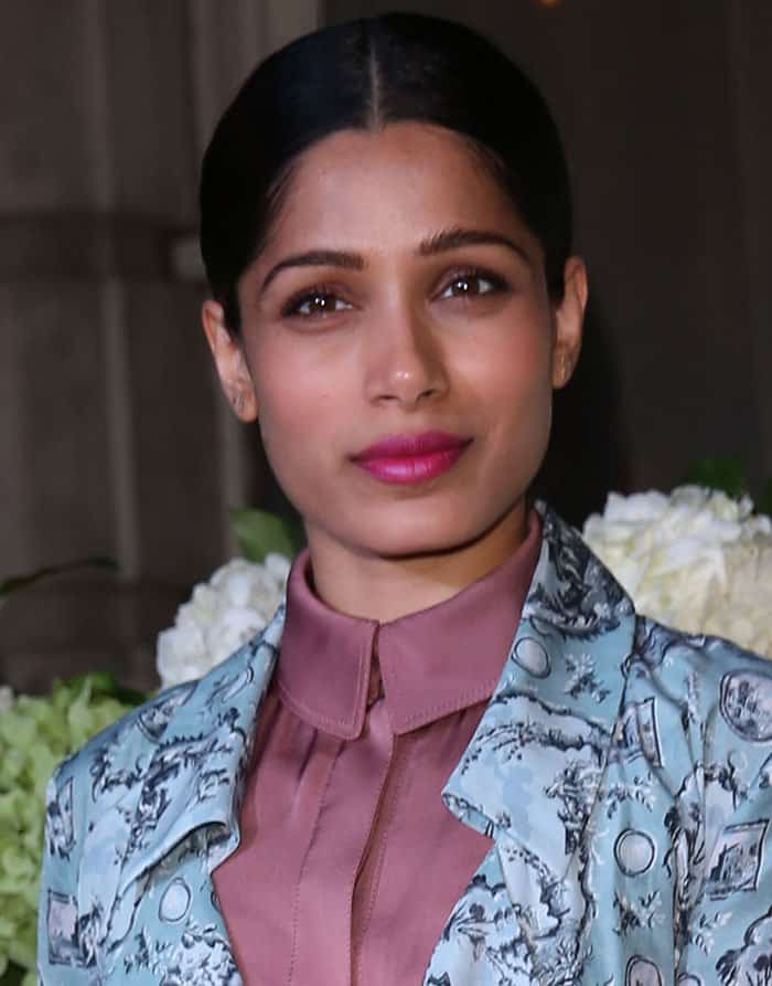 Freida Pinto added the final touches to her look with a sleek center-parted ponytail and a pop of fuchsia pink lipstick