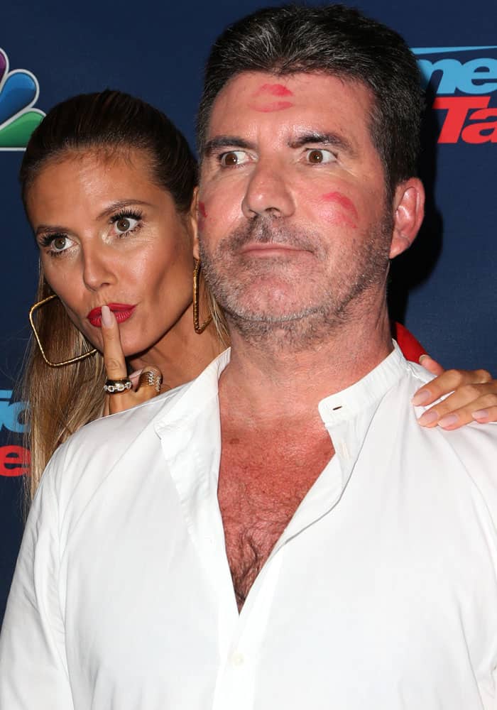 Heidi Klum playfully posed behind Simon Cowell after smothering his face with kisses