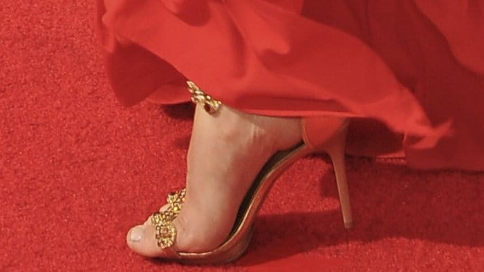 Jessie Graff adds a touch of glamour to her 5-foot-8-inch frame with gold-embellished Carmen Steffens sandals, perfectly peeking out from her red gown on the Emmy Awards red carpet
