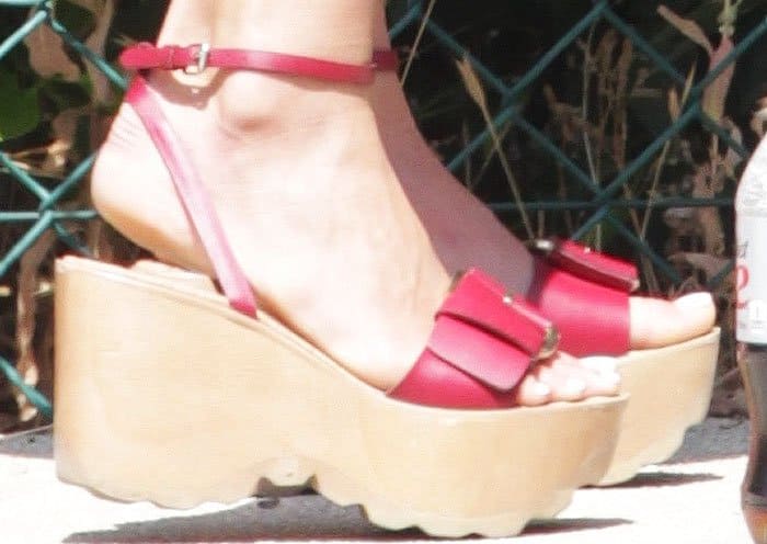 Jordana Brewster's feet in red Stella McCartney ridged-platform sandal wedges, adding bold height with thick wooden soles and ankle strap