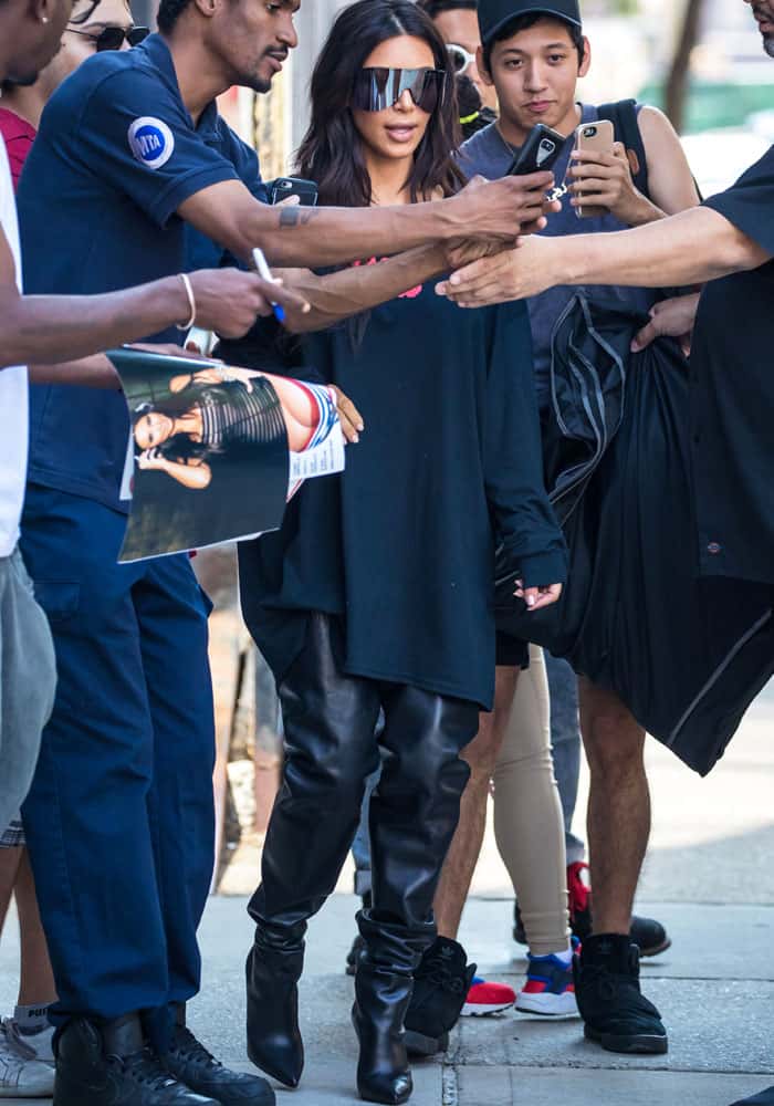 Kim stops to take photos with fans outside her New York apartment