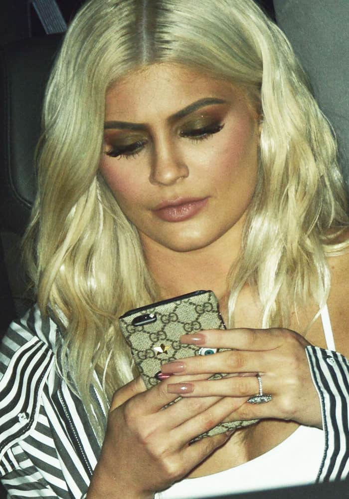 Kylie Jenner clutching an embroidered Gucci iPhone case while opening a pop-up shop in New York's meatpacking district for the Kendall + Kylie collection