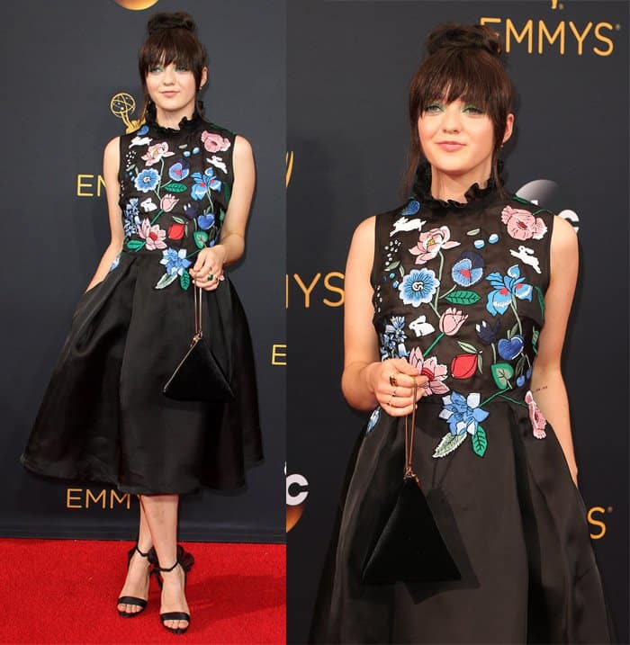Maisie Williams embraces her playful style in a floral-embroidered, tea-length dress paired with a unique triangular handbag and bold statement eye shadow at the 2016 Primetime Emmy Awards