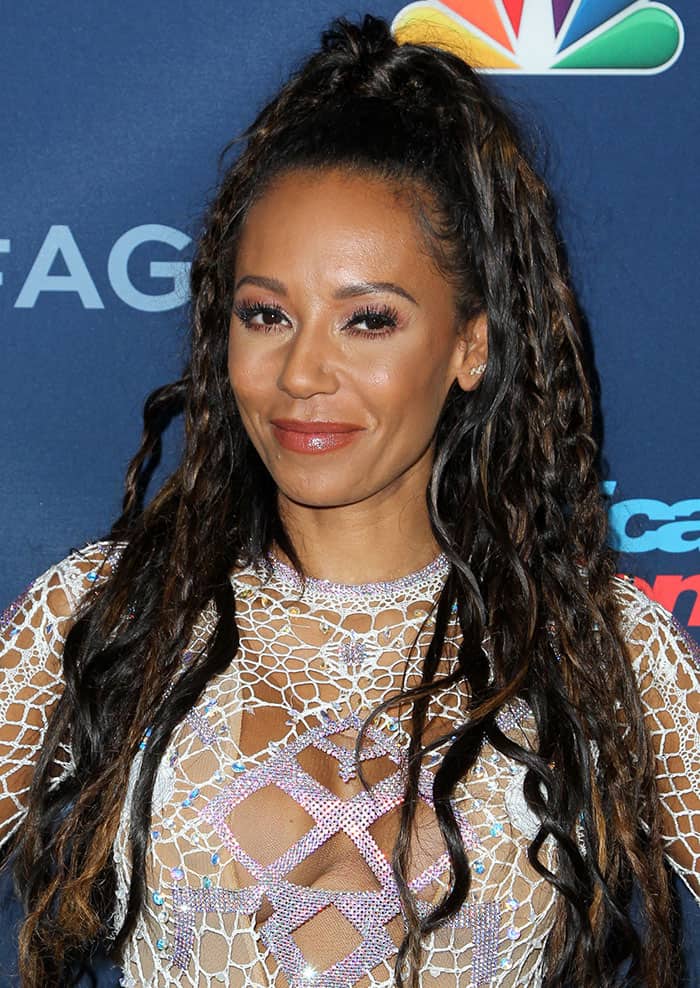 Mel B's long, curly half-up-do featured subtle braided accents, perfectly complementing her neutral makeup