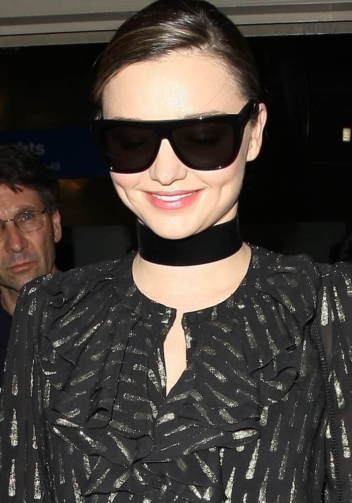 Miranda Kerr wears Saint Laurent Sl1 sunglasses with a Roberto Cavalli Fil Coupe ruffled blouse at the Los Angeles Airport (LAX)