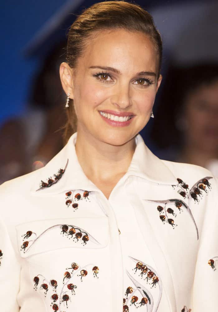 Natalie Portman wears a chic white mini-coat dress adorned with intricate floral details at the 2016 Toronto International Film Festival