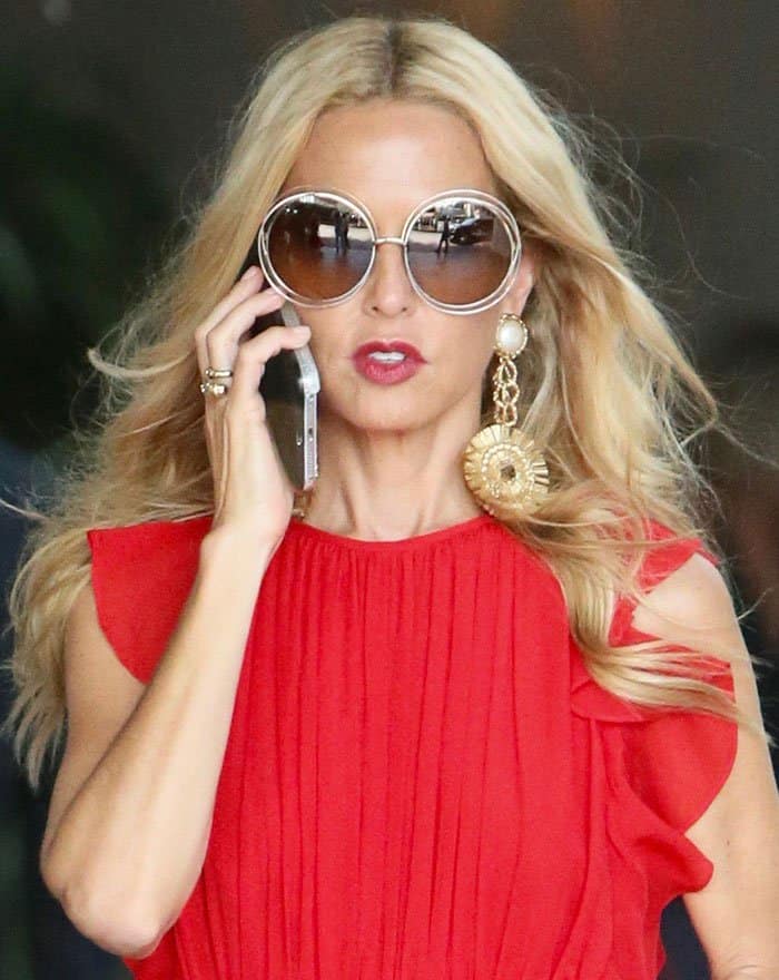 Shielding her eyes with chic round sunglasses, Rachel Zoe's beauty enhancements included tousled waves and a vibrant red lip