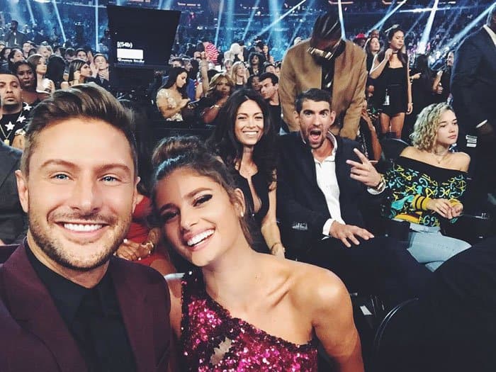 Taylor Hill and her boyfriend, Michael Shank, are photobombed by Michael Phelps and his fiancée Nicole Johnson at the 2016 MTV VMAs