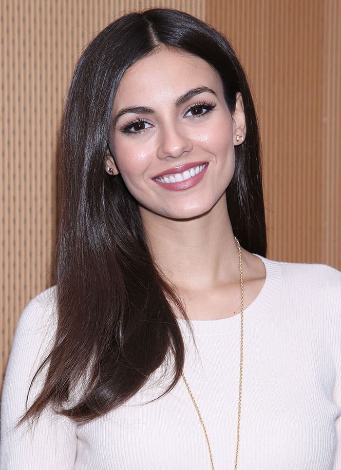 Victoria Justice's hair flowed effortlessly, and her makeup was understated, emphasizing her eyes with a touch of eyeshadow and mascara, while her lips sported a soft pink hue