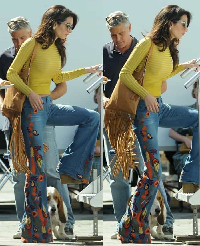 Amal Clooney perfects boho-chic in embroidered Alice + Olivia bell-bottom jeans, a ribbed mustard sweater, and a fringed suede bag, while George Clooney keeps it effortlessly cool in denim and sneakers during their stylish outing