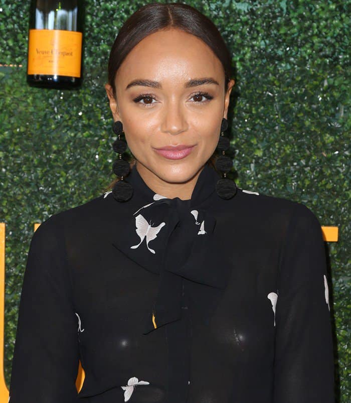 Ashley Madekwe's captivating ensemble boasted long sleeves, a flirtatious mini-length cut, and a striking arrangement of center front buttons accented by a chic necktie