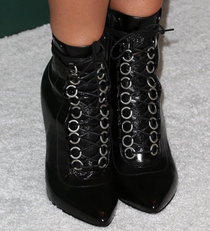 Ashley Tisdale's black Saint Laurent stiletto cat boots feature a sleek pointed-toe and edgy lace-up detailing with silver ring accents