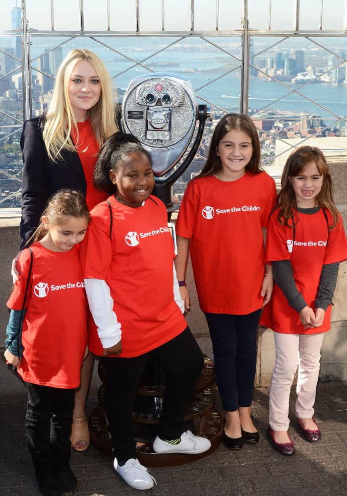 Dakota poses with the children from "Save the Children," which is an organization that she champions