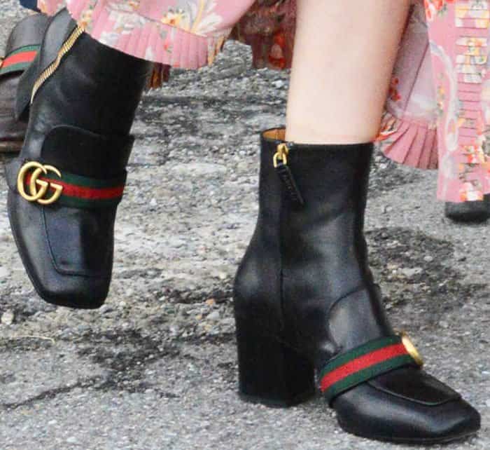 Dakota wore a pair of Gucci logo boots which are currently in stores