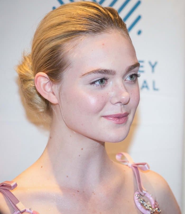 Elle Fanning tied her hair into an elegant bun and opted for a natural makeup look, allowing her stunning Prada creation to shine