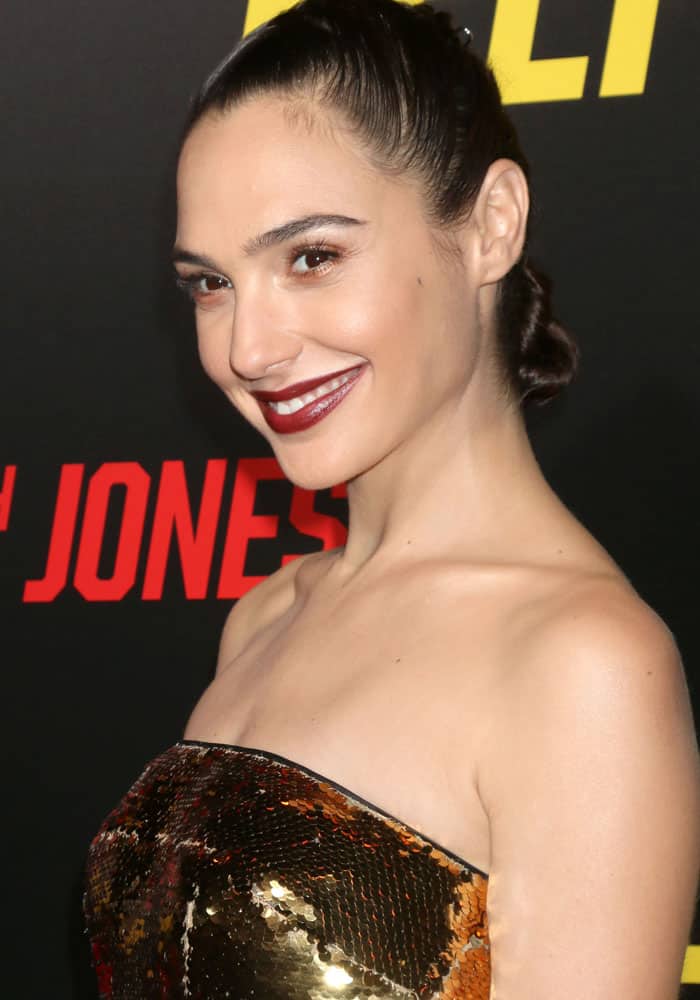 Complementing her glamorous attire, Gal Gadot opted for a sleek and chic braided hairstyle, while her choice of a vampy lip added a touch of sultriness to her overall look