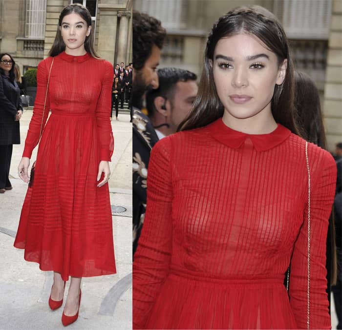 Actress Hailee Steinfeld looked stunning in a rich red Valentino dress featuring a delicate Peter Pan collar, fitted long sleeves, and a pleated, mid-length skirt at the Valentino show