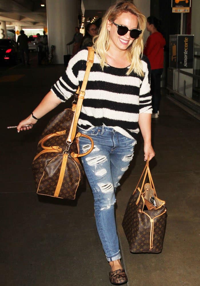 Hilary Duff lugged her Louis Vuitton bags with her as she arrived back home in good spirits