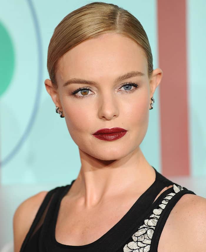 Kate Bosworth elegantly styled her hair in a sleek side-parted bun and enhanced the ensemble with a pop of vibrant red lipstick