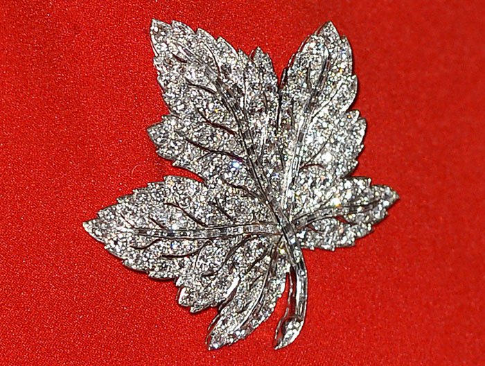 Kate Middleton adds a touch of heritage to her ensemble with Queen Elizabeth's sparkling maple leaf brooch, symbolizing the royal connection to Canada