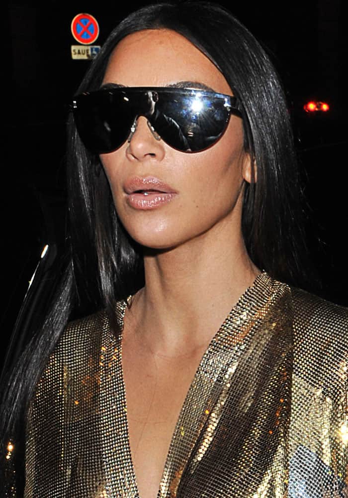 Kim Kardashian in a metallic Balmain Spring 2017 wrap dress styled with dark sunglasses