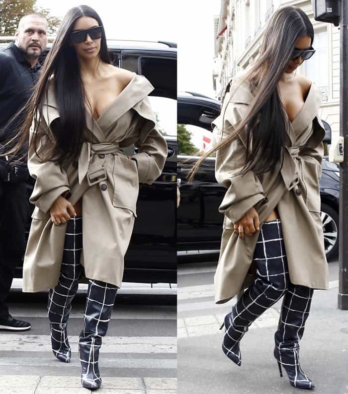 Kim Kardashian stuns in a belted trench coat paired with striking plaid thigh-high boots during Paris Fashion Week