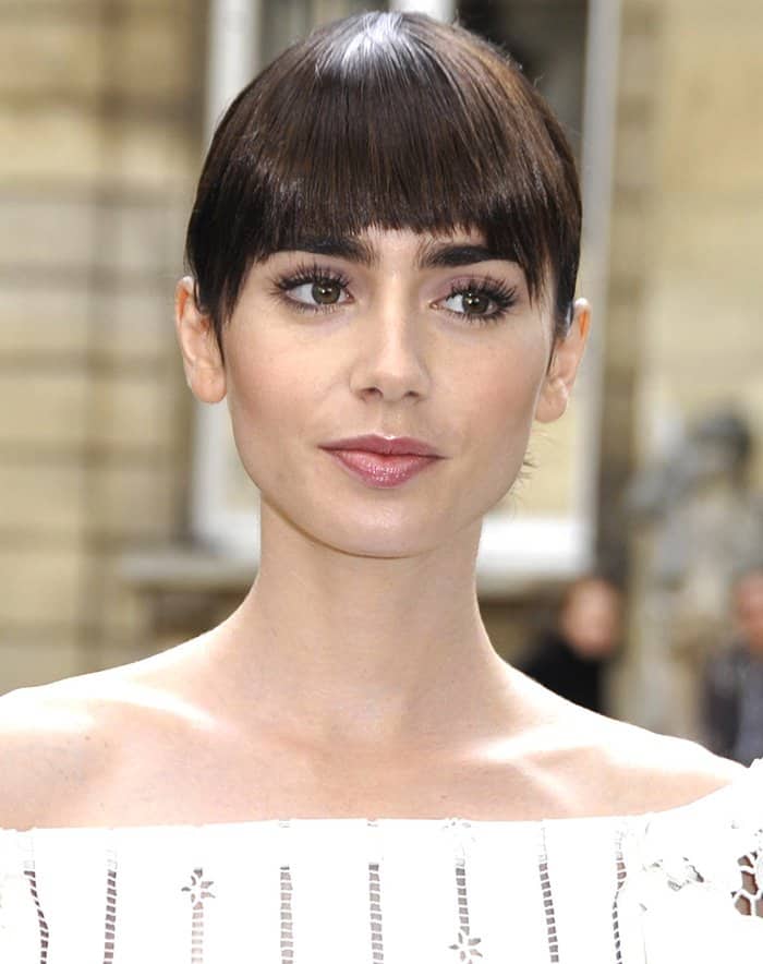 Lilly Collins' lustrous brunette tresses were expertly gathered into an updo, completing her chic and sophisticated appearance at the Valentino show