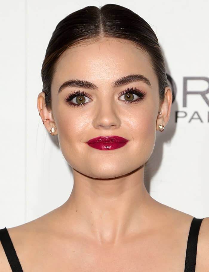 Lucy Hale shows off her diamond and gold earrings with a sleek middle-parted hairstyle