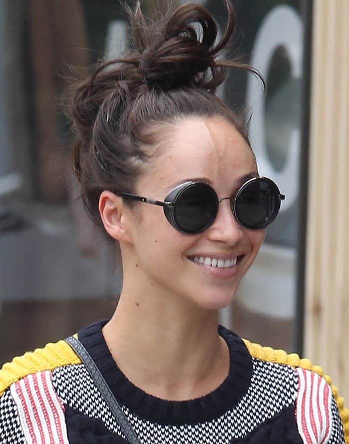 Cara Santana complements her bold outfit with subtle grace, opting for a casually tousled bun and minimal makeup for a fresh, natural look