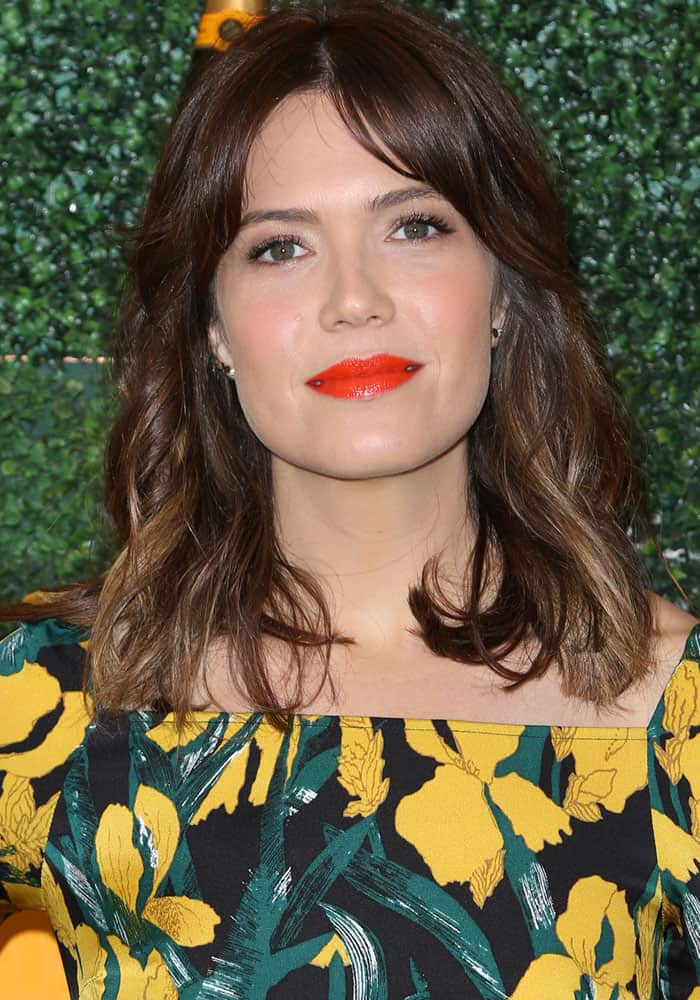 Mandy Moore's makeup featured peachy hues, with a bold choice of a bright red-orange lip, adding a touch of glamour to her garden outing at the 7th annual Veuve Clicquot Polo Classic at the Pacific Palisades