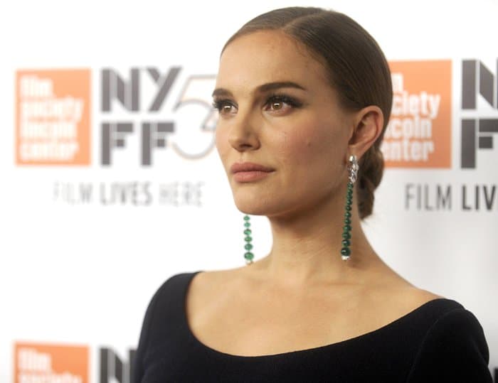 Natalie Portman pairs her sleek, low bun with stunning emerald drop earrings, exuding timeless elegance at the New York Film Festival