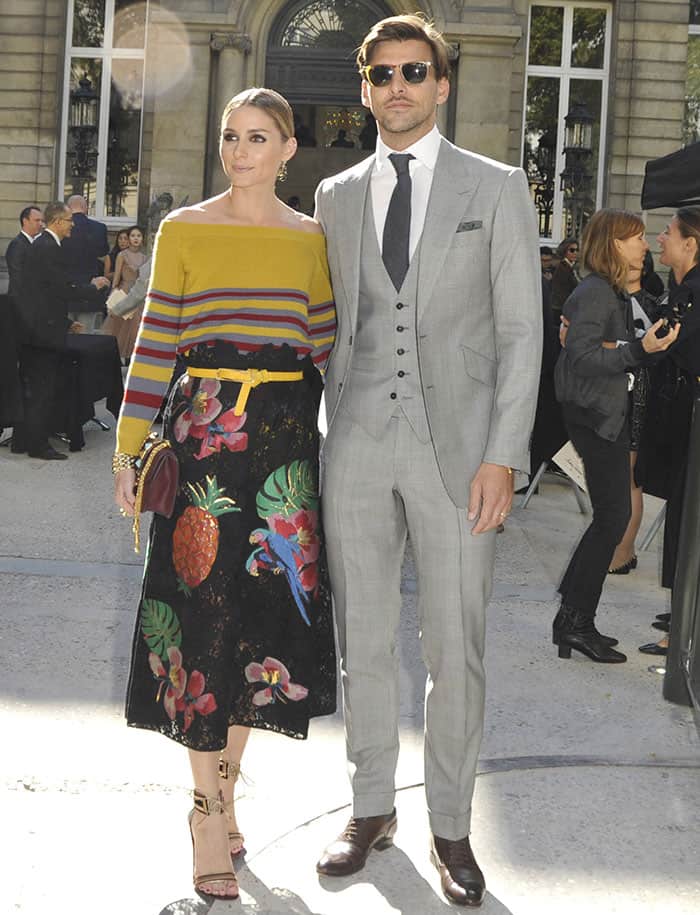 Olivia Palermo's husband, Johannes Huebl, matched her style with equal panache, sporting a three-piece gray suit at the Valentino show during Paris Fashion Week