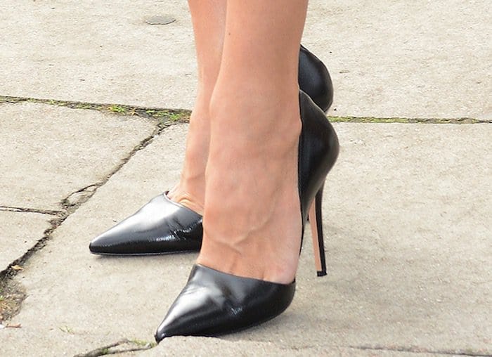 Pamela Anderson shows off her size 8.5 (US) feet in black pumps