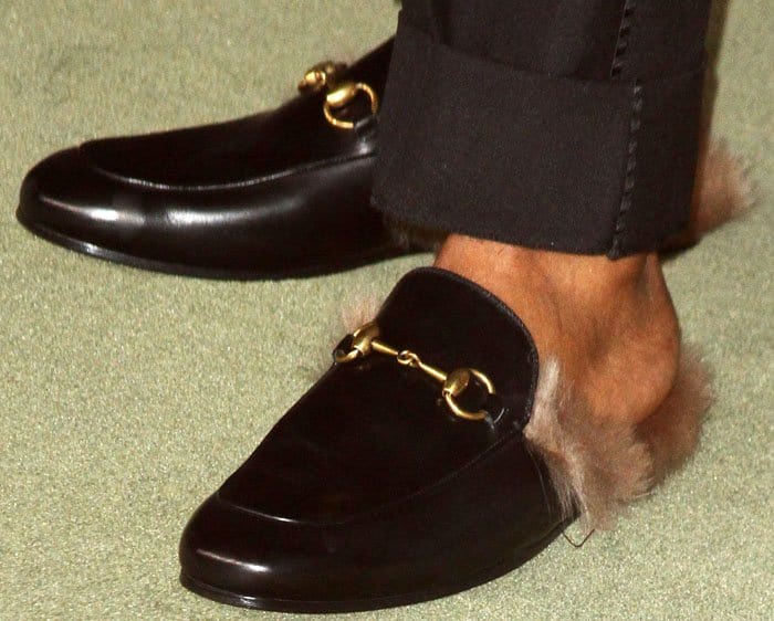 A$AP Rocky completes his look with luxurious black Gucci Princetown loafers featuring the iconic horsebit detail and plush fur lining