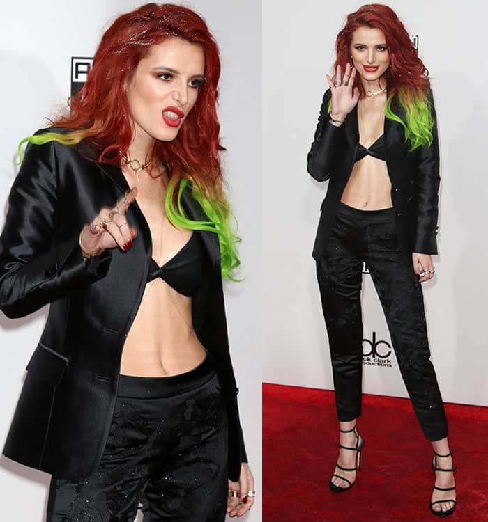 Bella Thorne strikes a fierce pose at the 2016 American Music Awards, sticking out her tongue and waving confidently while showcasing her daring black bra top and sleek tuxedo jacket ensemble at the American Music Awards 2016