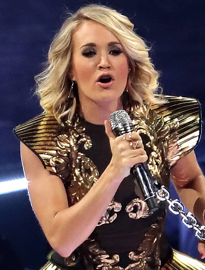 Carrie Underwood rocks soft, voluminous waves while delivering a powerful performance with a silver microphone in hand