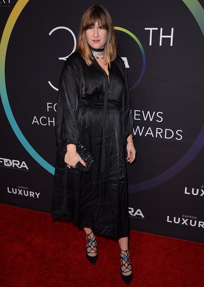 Isa Tapia at the 30th Footwear News Achievement Awards in New York City, showcasing her unique fashion sense in a dramatic black ensemble and statement accessories